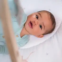 newborn playing in aden + anais activity gym