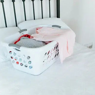 mom putting halo sleepsack swaddle in laundry basket