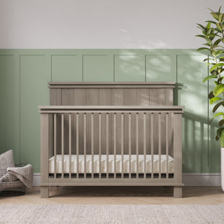 Child Craft Denman 4-in-1 Convertible Crib in Crescent Gray, made of pine wood with vertical slats and a solid headboard.