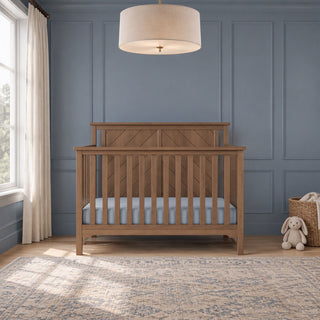 Child Craft Hampton Flat Top 4-in-1 Convertible Crib in Dusty Heather featuring a flat top and vertical slats in a room with blue paneled walls.