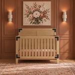 Lucas 4-in-1 Convertible Crib in Nutmeg with light wood finish and black corner accents for a modern farmhouse nursery.
