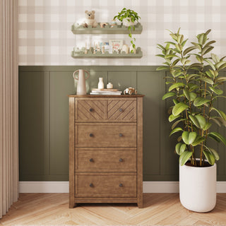 The Child Craft Atwood 4-Drawer Chest in Cocoa Bean is a dark wood four-drawer chest for a modern nursery, featuring chevron detailing on the top drawer front and dark hardware.
