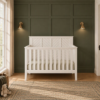 Matte white Atwood 4-in-1 Convertible Crib with a paneled headboard featuring a diagonal slat design.