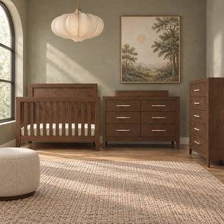 A nursery set including a wooden crib, a herringbone dresser with a changing top, and a Child Craft Kieran 5-Drawer Chest, all in a matching toasted chestnut finish with horizontal metal pulls.