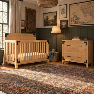 Child Craft Lucas 2-Piece Nursery Set with a rustic wooden crib and a three-drawer dresser with black corner hardware, placed in a room with an ornate rug.
