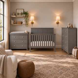 A matching gray baby nursery furniture set featuring a crib, a changing table with drawers, and an Atwood 4-Drawer Chest, Lunar Gray.