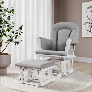 The softly lit room features the Child Craft Scout 3 Piece Nursery Set, including a gray upholstered glider chair with matching ottoman placed on a round rug beside a large potted plant, all set against beige walls adorned with abstract wall art.