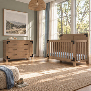 The Child Craft Lucas 2-Piece Nursery Set with Crib and Dresser features a wooden crib with a blue mattress and a matching three-drawer dresser with black corner accents.