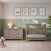 A six-drawer Child Craft Denman Double Dresser in Crescent Gray sits next to a matching crib in a room with sage green wainscoting and four botanical framed prints on the wall.