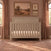 Child Craft Kieran 4-in-1 Convertible Crib in Crescent Gray, a wooden crib featuring a herringbone-patterned headboard, shown in a bedroom setting.
