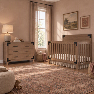 A Child Craft Lucas 4-in-1 Convertible Crib in Dusty Heather and a matching three-drawer dresser with black corner accents, arranged in a rustic nursery with a patterned area rug.