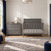 A gray Child Craft Atwood 3-Drawer Dresser, Lunar Gray with diamond-patterned drawer fronts next to a matching crib in a nursery.