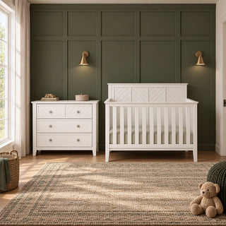 A white Child Craft Atwood 3-Drawer Dresser, Matte White sits next to a matching white slatted crib in a nursery.