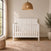 A matte white Atwood 4-in-1 Convertible Crib featuring a chevron-patterned headboard.