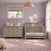 A light-gray Child Craft Denman Double Dresser in Crescent Gray with six drawers stands next to a matching crib in a room with light purple walls.