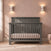 Child Craft Denman 4-in-1 Convertible Crib in Midnight Gray, made of pine wood with a dark gray finish, slatted sides, and a solid headboard.