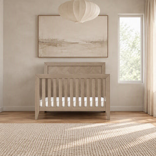 Kieran 4-in-1 Convertible Crib in Crescent Gray, featuring a light gray finish and a tall, paneled headboard.