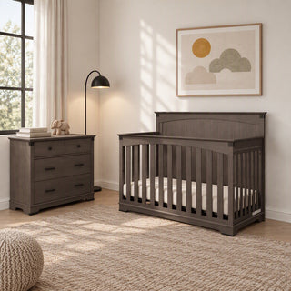 A dark gray Child Craft crib and matching Redmond 3 Drawer Dresser in a bedroom.