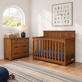 Wooden crib and matching Child Craft Redmond 3 Drawer Dresser in Coach Cherry in a nursery with an alphabet wall print.