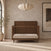 Child Craft Surrey Hill 4-in-1 Convertible Crib in toasted chestnut with a paneled headboard and a white mattress.