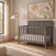Lunar Gray Child Craft Atwood 4-in-1 Convertible Crib with a paneled headboard in a nursery.