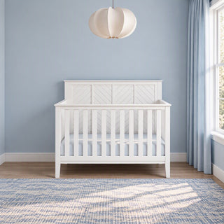 Matte White Child Craft Atwood 4-in-1 Convertible Crib featuring a chevron pattern on the headboard and baby-safe finishes.