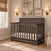 A dark wood Redmond 4 Piece Nursery Set with Crib featuring a mattress with a star pattern, situated in a nursery.