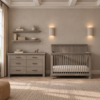 Crescent Gray Child Craft Denman Double Dresser with six drawers, positioned next to a matching crib in a nursery furniture set.