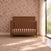 A toasted chestnut Child Craft Kieran 4-in-1 Convertible Crib featuring a slatted design and a mattress.
