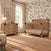 A rustic Child Craft Lucas 4-in-1 Convertible Crib in Dusty Heather and a matching dresser with dark hardware in a room with floral wallpaper.