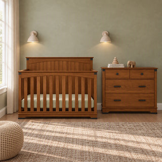 A wooden baby crib and matching Child Craft Redmond 3 Drawer Dresser in Coach Cherry in a nursery.