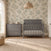 A gray Child Craft Atwood 3-Drawer Dresser, Lunar Gray sits next to a matching crib with a patterned mattress in a nursery.