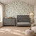 A gray wooden Child Craft Denman Double Dresser, Midnight Gray with six drawers sits next to a matching crib in a room with floral wallpaper and a textured rug.