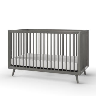 The Child Craft Cranbrook 4-in-1 Convertible Crib in Lunar Gray features modern vertical slats on all sides and a white mattress, shown against a plain white background—perfect nursery furniture.