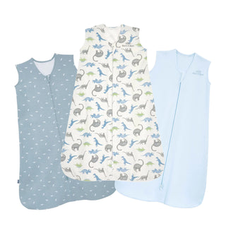 The HALO SleepSack Cotton Wearable Blanket Bundle includes three sleeveless blankets with front zippers—light blue, blue with white prints, and white with colorful dinosaurs—providing a cozy alternative to traditional cotton baby blankets.