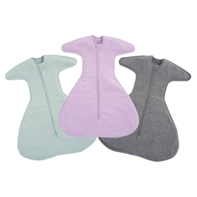 The HALO SwaddleStretch Newborn Swaddle Bundle includes three cotton swaddles in pastel green, light purple, and dark gray with central zippers and wing-like sleeves, displayed side by side on a white background.