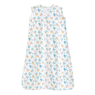 The HALO Disney™ Wearable Blanket Cotton TOG 0.5 is a white sleeveless sleep sack with a front zipper, featuring pastel Mickey Mouse head prints for safe baby sleep.