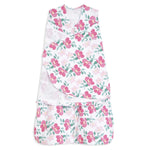 The HALO Swaddle 100% Cotton TOG 1.5 has a sleeveless design with adjustable wings and features a floral pattern of pink flowers and green leaves on white, promoting healthy hip development.