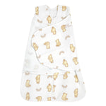 The HALO Disney™ Winnie the Pooh Swaddle Micro-Fleece TOG 3.0 is a white wearable sleep sack for babies with a wrap swaddle design, bottom zipper, and bear and sun pattern in light brown and yellow.