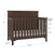 The Child Craft Woodland 4-in-1 Convertible Crib in Brushed Truffle features a high back panel, slatted sides, and three mattress heights for newborns to standing toddlers. Dimensions: 47