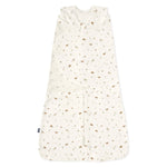 The HALO Swaddle 100% Cotton TOG 1.5 features a cream color with brown and green animal and tree prints. It has a sleeveless design, adjustable wings, and a Velcro-secured wrap-around flap to support healthy hip development for your little one.