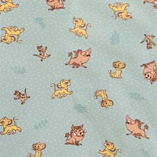 Patterned fabric with cartoon animals resembling lions and warthogs on a light blue background. The characters are playfully arranged in various poses, surrounded by subtle leaf patterns.