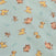 Patterned fabric with cartoon animals resembling lions and warthogs on a light blue background. The characters are playfully arranged in various poses, surrounded by subtle leaf patterns.