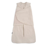 The HALO SuperSoft Bamboo Swaddle TOG 2.0 in beige is a sleeveless swaddle made from soft bamboo, featuring a front zipper and adjustable Velcro wings for secure swaddling.