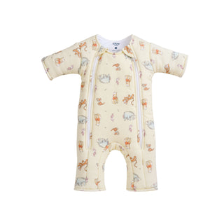 The Disney® Winnie the Pooh Baby Merlin’s Magic Sleepsuit® by HALO, crafted from 100% cotton, features charming animal illustrations in light beige and is designed with two diagonal front zippers—ideal for swaddle transitions or offering comfort during sleep regression. Displayed on a white background.