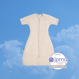 A HALO Easy Transition SleepSack TOG 1.5 quilted short-sleeve baby sleep sack with a front zipper, featuring a 2024 JPMA Innovation Awards badge against a blue sky background.