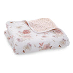 The boutique cotton muslin dream blanket by aden + anais is crafted from 100% cotton muslin with a pattern of pink and white flowers and birds. It features a breathable texture and a corner design with pink polka dots, making it perfect for your little one.