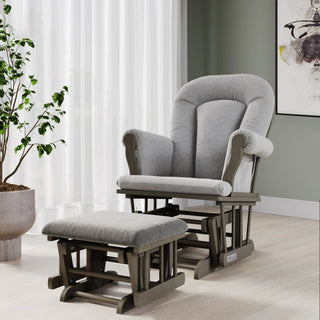 The Child Craft Hampton Arch Top 5 Piece Nursery Set, featuring a gray upholstered glider chair with matching ottoman, is arranged on a light wood floor next to a potted plant, white curtains, and abstract wall art in a modern room, complemented by the sleek dresser with changing tray from the same set.
