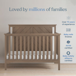 A Child Craft Hampton Flat Top 4-in-1 Convertible Crib in Dusty Heather stands by a light wall with a white mattress. Text highlights “Loved by millions of families,” 70+ years’ expertise, baby-safe finishes, and top safety certifications.