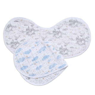 Displayed are two aden + anais boutique 100% cotton muslin burpy bibs. One showcases a gray castle pattern reminiscent of Harry Potter, while the other features blue clouds with small stars. Both are designed to fit perfectly over the shoulder as stylish baby essentials.